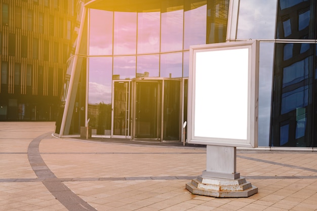 Leeg reclameaanplakbord op voorzijde van bedrijfsgebouw. Banner op achtergrond van wolkenkrabber is gemaakt in moderne stijl. Architectuur van het inbouwen van de zakenwijk van de metropool. Auteursrechtruimte