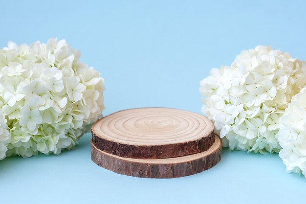 Leeg rond houten podium voor productpresentatie witte bloemen op blauwe achtergrond