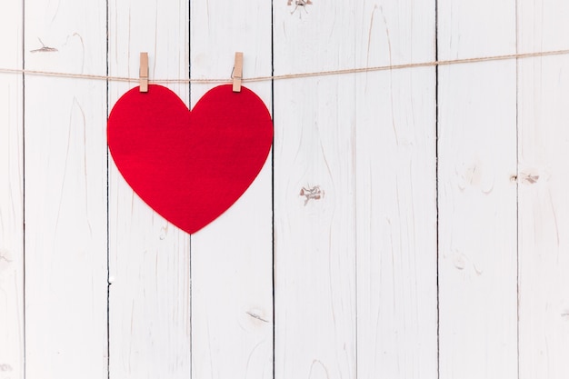 Leeg rood hart op wit hout hangen met ruimte voor Valentijn en bruiloft achtergrond.