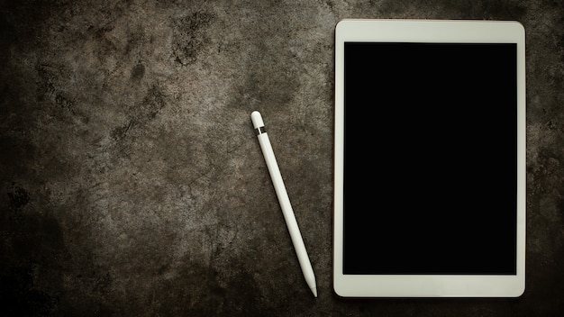 Foto leeg scherm tabletpen en woord leren op houten kubusblok op zwarte tafelachtergrond