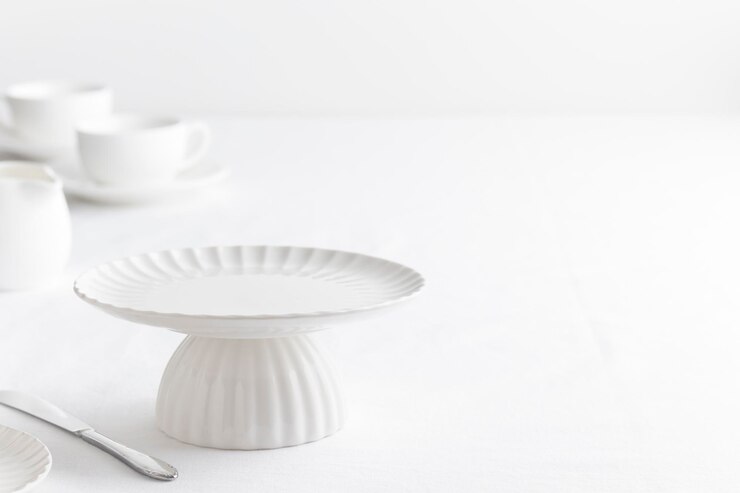Leeg servies wit bord cakestand op witte tafel als achtergrond voor een dessert horizontale banner