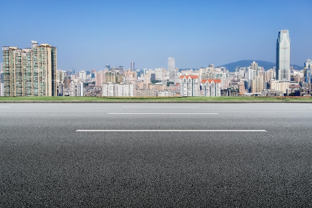 Leeg stadsweg met moderne stedelijke skyline