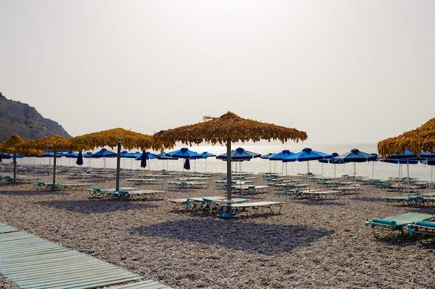 Foto leeg strand met parasols en ligbedden selectieve focushet laagseizoenzomervakantie en covidbeach w