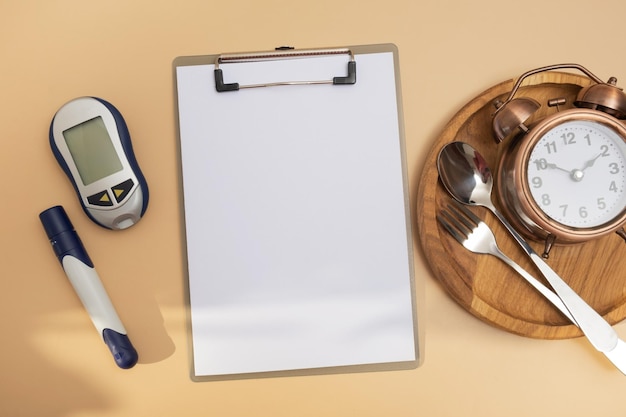 Leeg tekstbord en glucometer en bestek met wekker op plaat plat bovenaanzicht Mock up diabetes thema