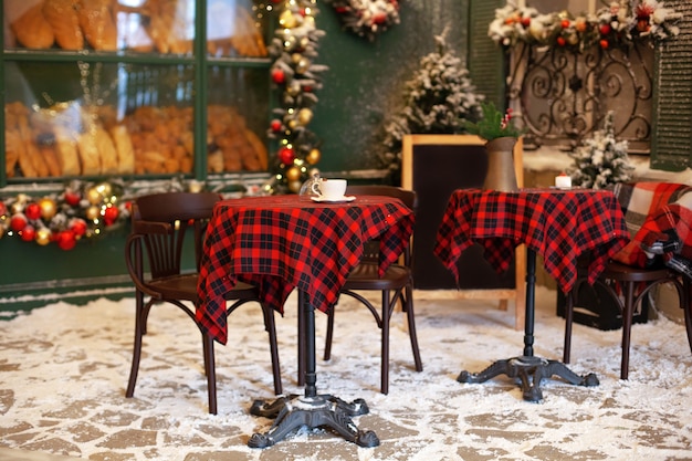 Leeg terras van café en restaurant met tafels en stoelen ingericht voor Kerstmis. feestelijk decor