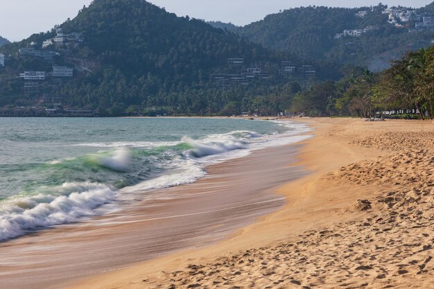 Leeg tropisch zonnig strand met golven op de kust en bergen op de achtergrond Samui Thailand