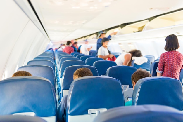 Leeg vliegtuiginterieur met weinig mensen en stewardess tijdens coronaviruspandemie