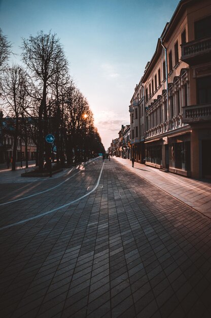 Foto leeg weg te midden van gebouwen tegen de hemel tijdens zonsondergang