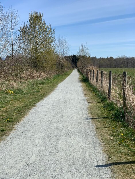 Foto leeg weg te midden van het veld tegen de lucht