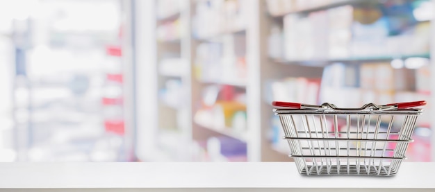 Leeg winkelmandje op de teller van de apotheekdrogisterij met onscherpte planken van geneeskunde en vitamine supplementen achtergrond