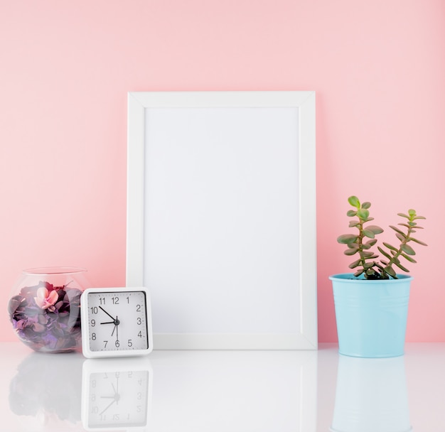 Leeg wit frame en plant cactus, op een witte tafel tegen de roze muur kopie