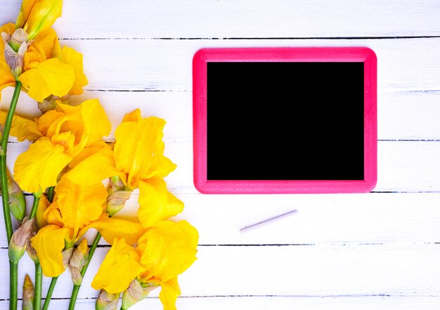 Foto leeg zwart bord in een rood kader op een witte houten ondergrond