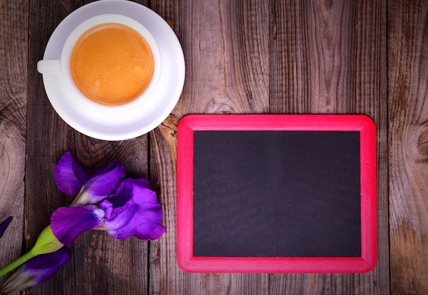 Leeg zwart schoolbord met een kopje koffie op een grijze ondergrond