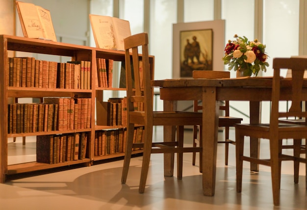 Foto leegte stoelen en tafel thuis naast de boekenplank.