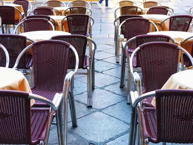 Foto leegte stoelen en tafels in het café op de stoep.