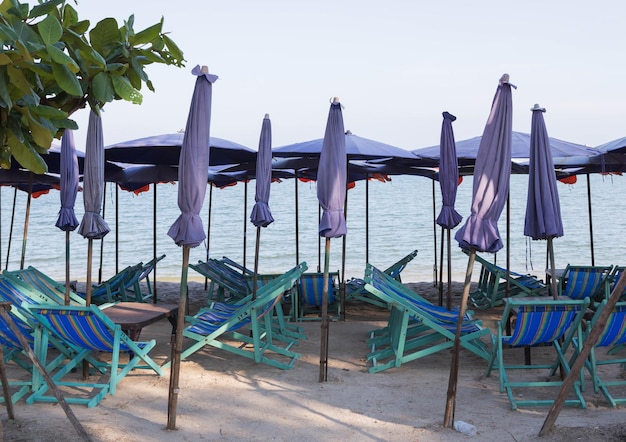 Foto leegte stoelen en tafels op het strand tegen de lucht