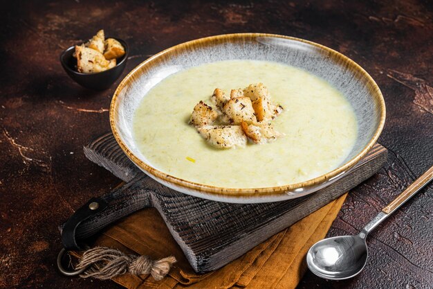 Leek soup Vichyssoise with croutons. Dark background. Top view.