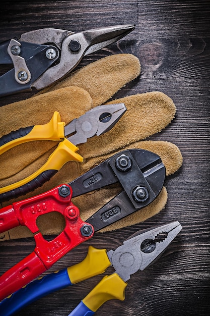 Foto leer beschermende handschoen staaldraadkniptang op houten achtergrond