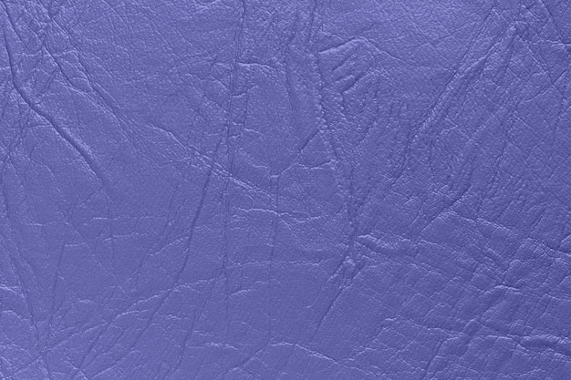 Leer vervangend oppervlak met vouwen en rimpels in violette kleur als achtergrond of textuur Trendy kleur van het jaar 2022