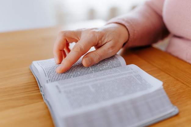 Leergierige senior close-up van bijgesneden handen met leerboek