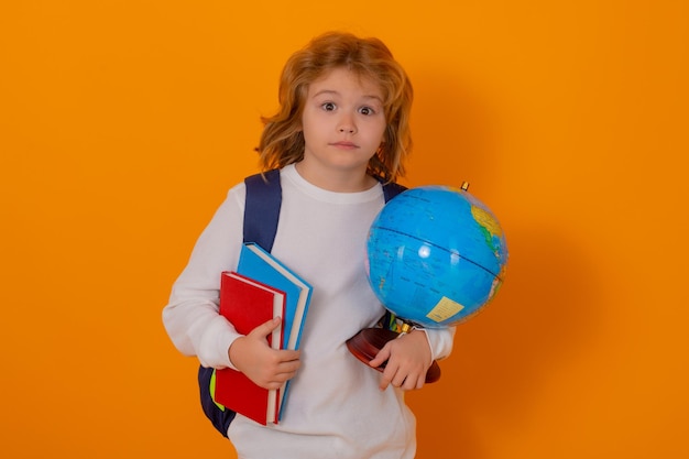 Leerling nerd schooljongen schooljongen houdt wereldbol en boek geïsoleerd op gele studio achtergrond schoo