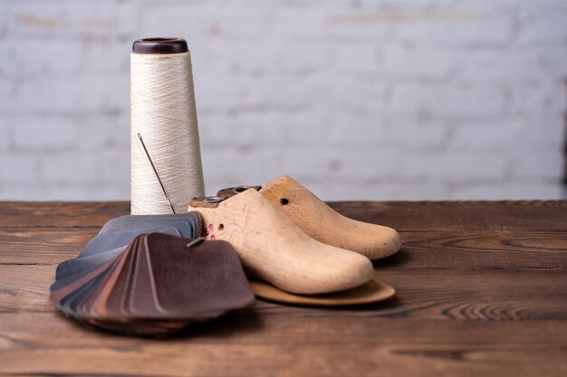 Foto leerstalen voor schoenen en klompleest op donkere houten tafel. designer meubelkleding. schoenmaker werkruimte.