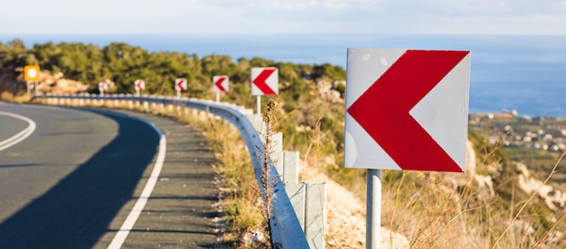 Segnale di svolta a sinistra: i segnali stradali avvertono di una svolta brusca su una strada stretta.