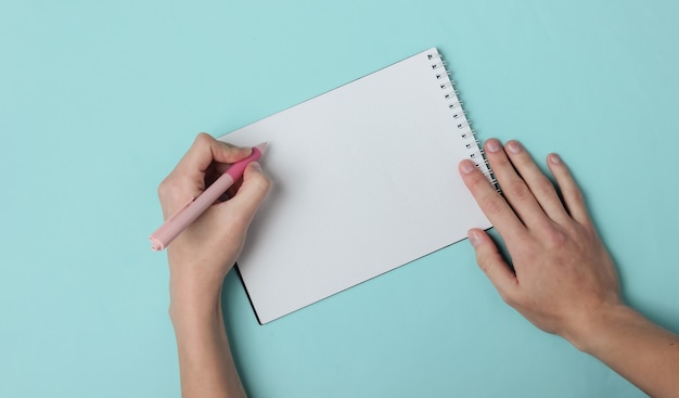 Lefthanded woman writes with a pen in a diary