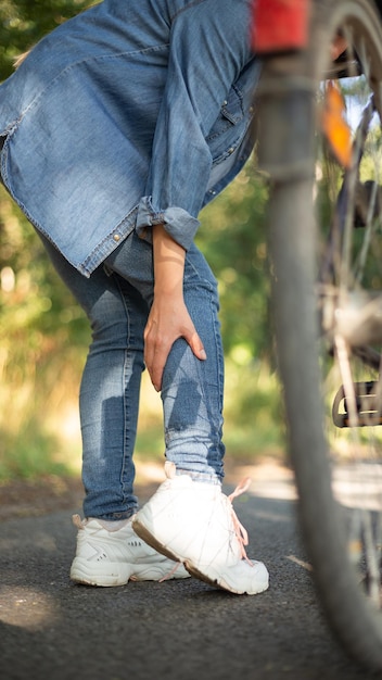 Leg pain cramp after cycling girl in jeans