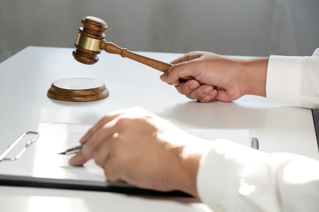 弁護士は、小槌と法的な正義と弁護士の概念との署名済みの契約をクライアントに提示します