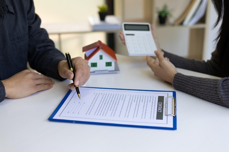 फोटो legally signing a real estate contract agreement real estate agents calculate and quote a house for sale with a calculator