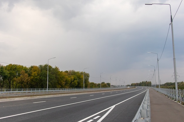 Lege asfaltweg met lantaarnpalen bij zonsondergang