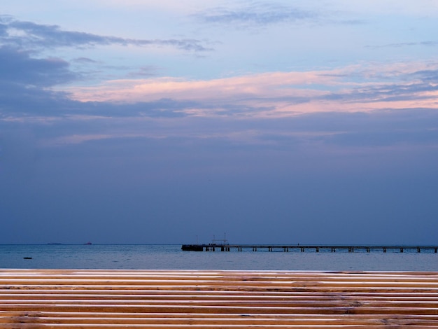 lege bamboe houten tafel met palmtakken op mooie onscherpe intreepupil blauwe zee achtergrond