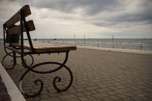 Lege bank op de promenade in bewolkt weer