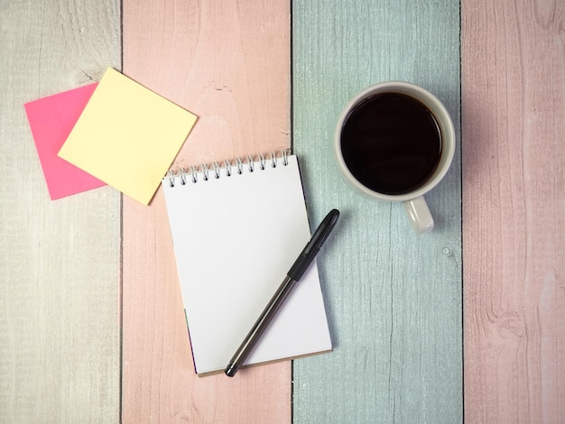 Lege blocnote en pen met een kopje koffie op de achtergrond van een houten tafel Bedrijfsconcept met kopieerruimte voor elk ontwerp