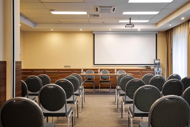 Lege conferentiezaal met stoelen en projectiescherm