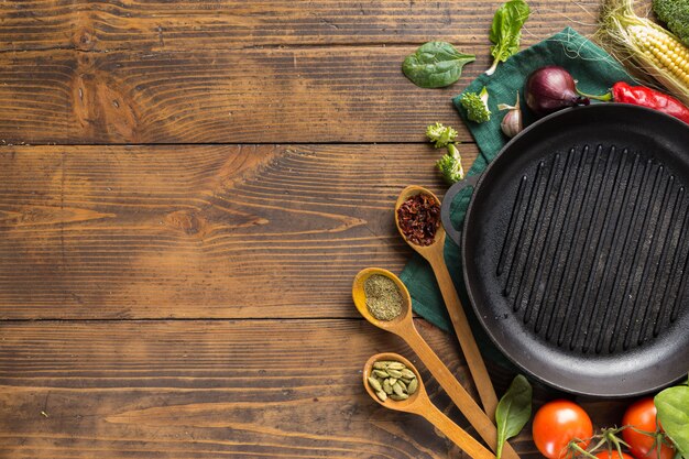 Lege grillpan met verse vegetarische verschillende ingrediënten voor het koken van veganistisch gegrild voedsel boven het hoofd