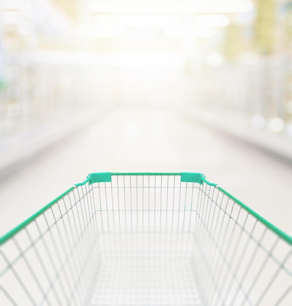 Lege groene winkelwagen in het gangpad van de supermarkt