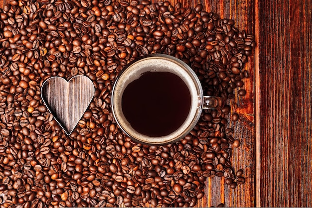 Lege hartvorm gemaakt binnenkant van koffiebonen achtergrond kopje koffie met espresso drinken americano...