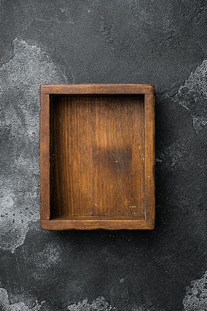 Lege houten kist met kopie ruimte voor tekst of voedsel bovenaanzicht plat lag op zwarte donkere stenen tafel achtergrond