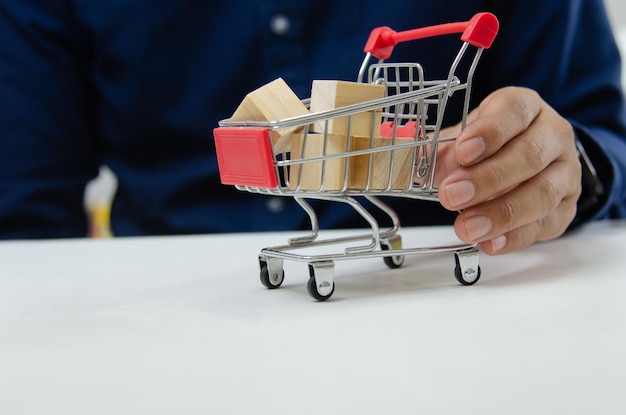 Lege houten kubus op winkelwagentje op tafel Concept promotie marketing handel en boodschappen bezorgen