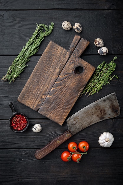 Lege houten snijplank, met slagersmes, plat lag, op zwarte houten tafel