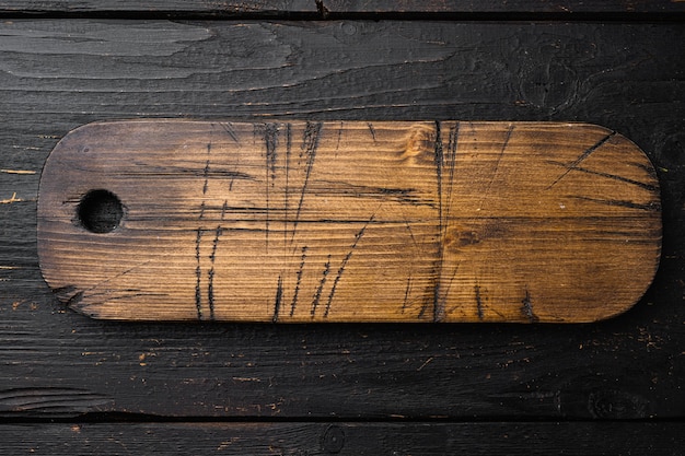 Lege houten snijplankenset, bovenaanzicht plat, met kopieerruimte voor tekst of uw product, op zwarte houten tafelachtergrond