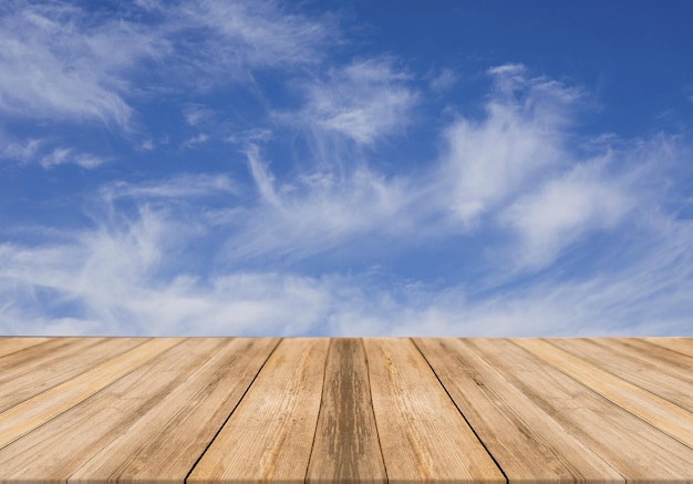 Lege houten tafel met bewolkte hemel op achtergrond