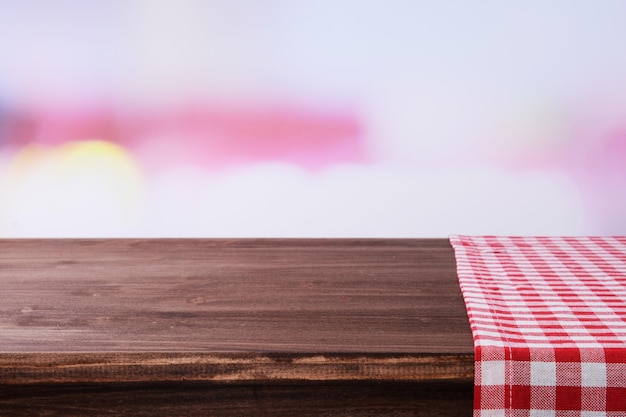 Lege houten tafel met servet en lichte achtergrond