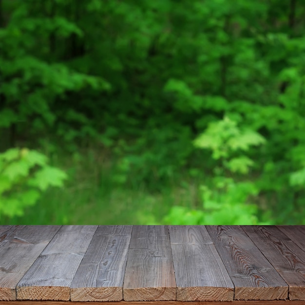 Lege houten tafel over bokeh achtergrond. Onscherpe achtergrond.