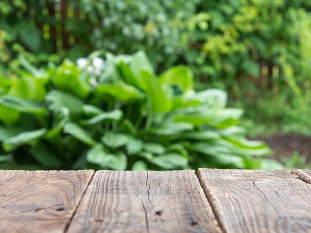 Lege houten tafel tuinzicht bokeh voor catering of food product showcase mockup template