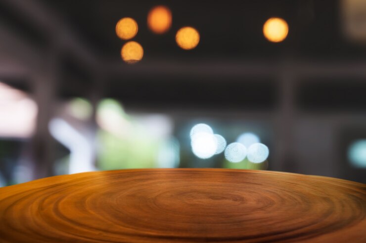lege houten tafel voor vage coffeeshop café of werkplek achtergrond