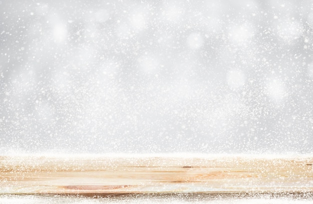 Lege houten tafelblad met sneeuwval van winterseizoen achtergrond. Voor kerstdag en Nieuwjaar concept.