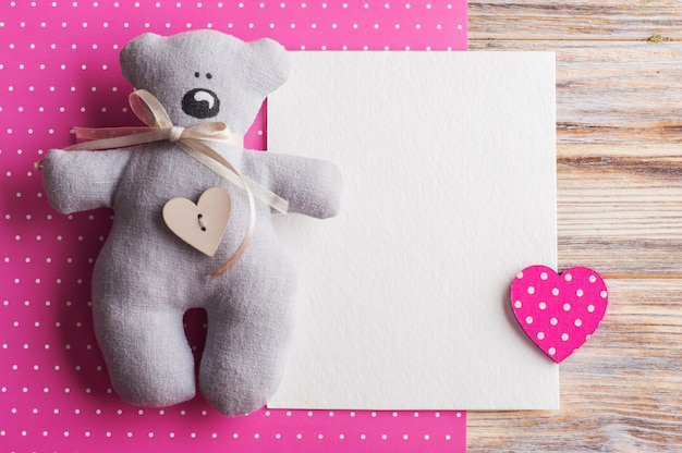 Lege kaart op roze achtergrond met teddybeer
